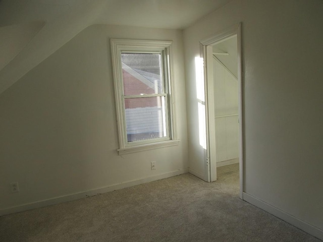 bonus room with light colored carpet and lofted ceiling