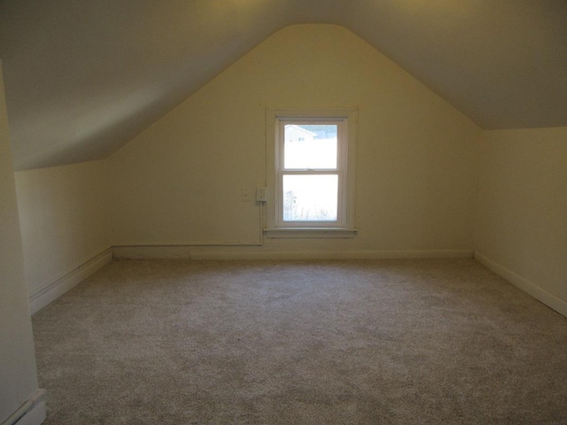 bonus room with light carpet and vaulted ceiling