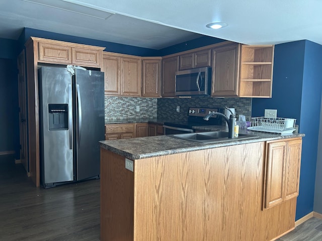 kitchen with stainless steel appliances, dark hardwood / wood-style flooring, kitchen peninsula, sink, and backsplash