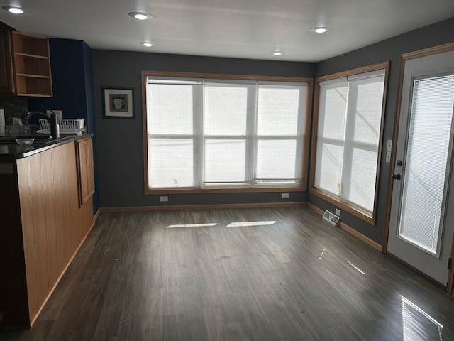 unfurnished dining area featuring dark hardwood / wood-style floors