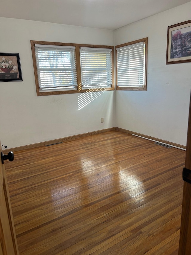 unfurnished room with dark hardwood / wood-style floors