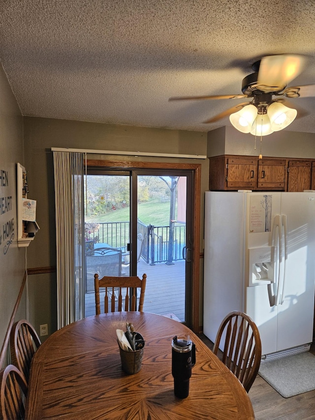 dining area with ceiling fan, a textured ceiling, and light hardwood / wood-style floors