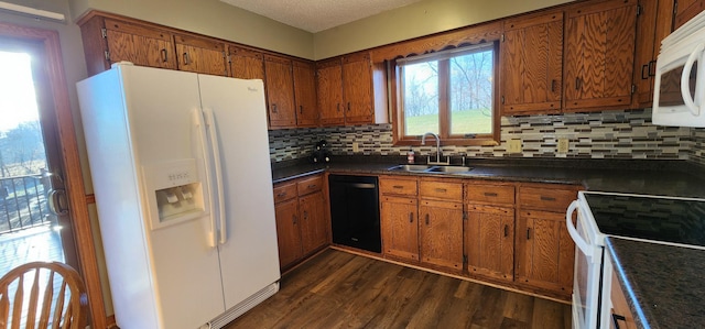 kitchen featuring a wealth of natural light, dark hardwood / wood-style floors, sink, and white appliances