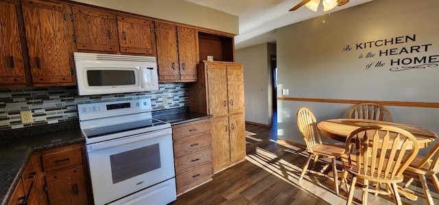 kitchen with dark hardwood / wood-style flooring, tasteful backsplash, and white appliances