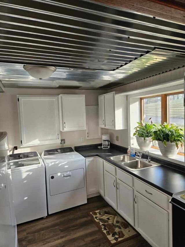 kitchen with electric range, sink, white cabinetry, separate washer and dryer, and dark hardwood / wood-style flooring