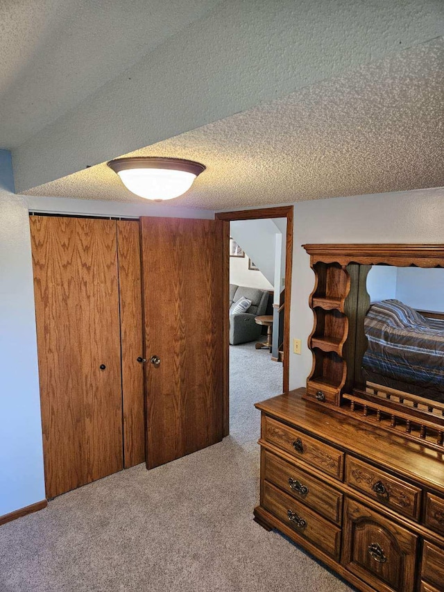 hall featuring light carpet and a textured ceiling