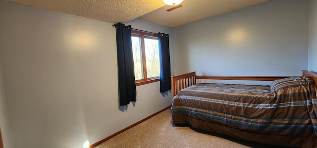 bedroom with ceiling fan, a textured ceiling, and carpet flooring