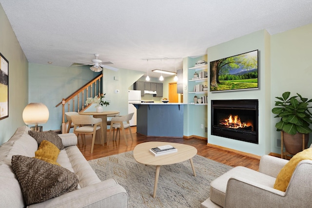 living room featuring a textured ceiling, hardwood / wood-style flooring, ceiling fan, and rail lighting