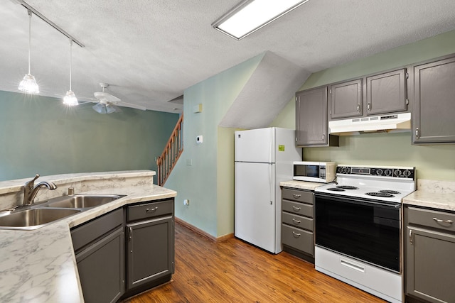 kitchen featuring decorative light fixtures, gray cabinets, sink, hardwood / wood-style flooring, and white appliances