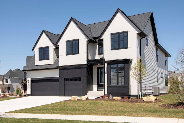 view of front of house with central AC unit, a front yard, and a garage