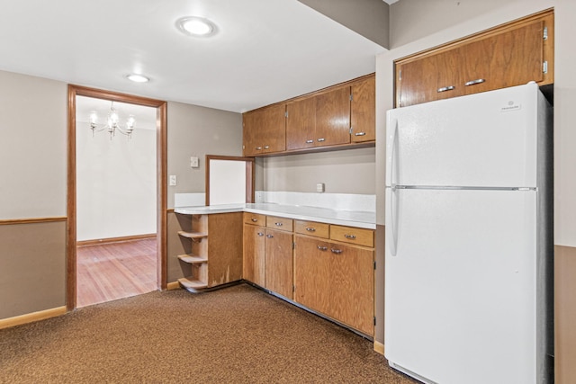 kitchen with carpet, white fridge, and a notable chandelier