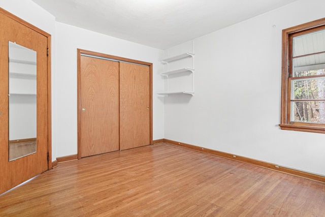 unfurnished bedroom with light wood-type flooring and a closet