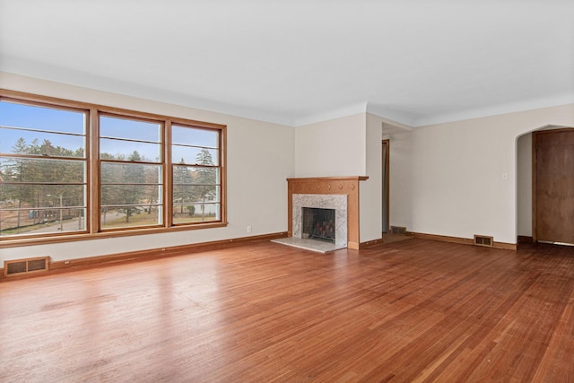 unfurnished living room with hardwood / wood-style floors and a healthy amount of sunlight