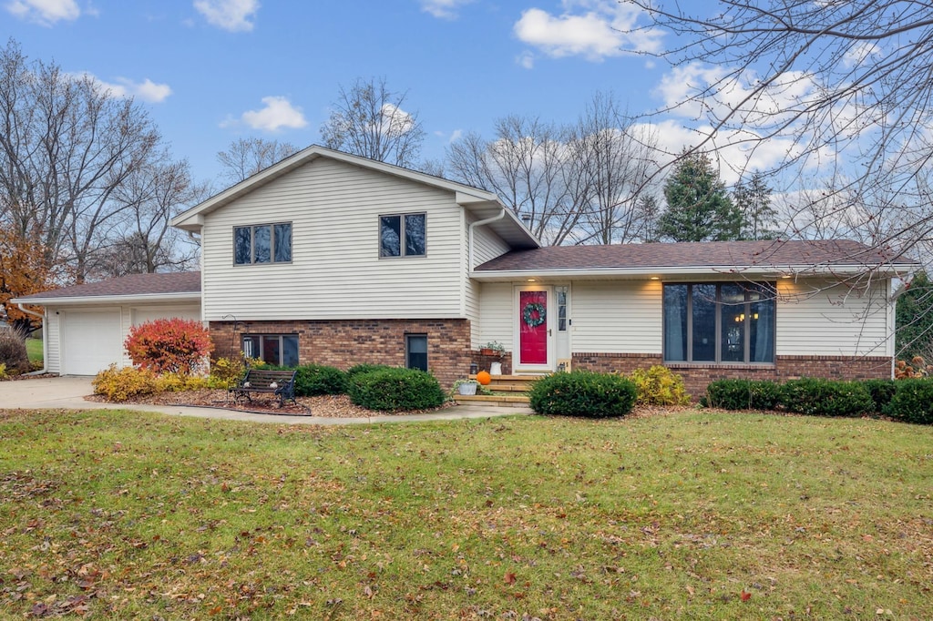 split level home with a garage and a front lawn