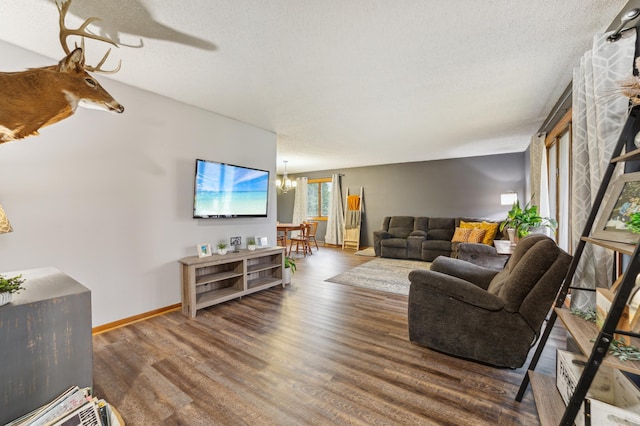 living room featuring dark hardwood / wood-style flooring, a textured ceiling, and a chandelier