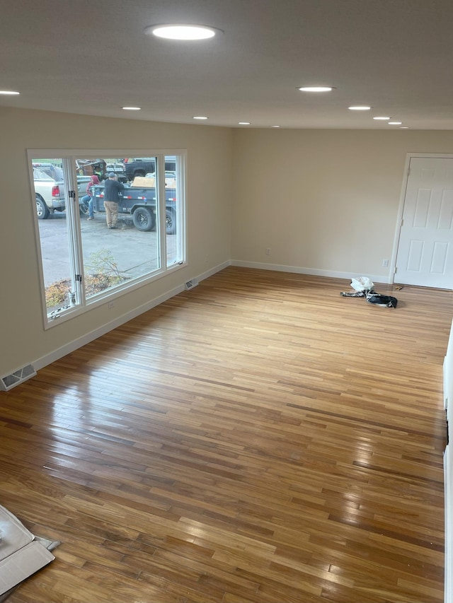 unfurnished room with recessed lighting, visible vents, baseboards, and wood finished floors