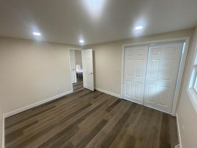 unfurnished bedroom featuring dark wood-type flooring, recessed lighting, a closet, and baseboards