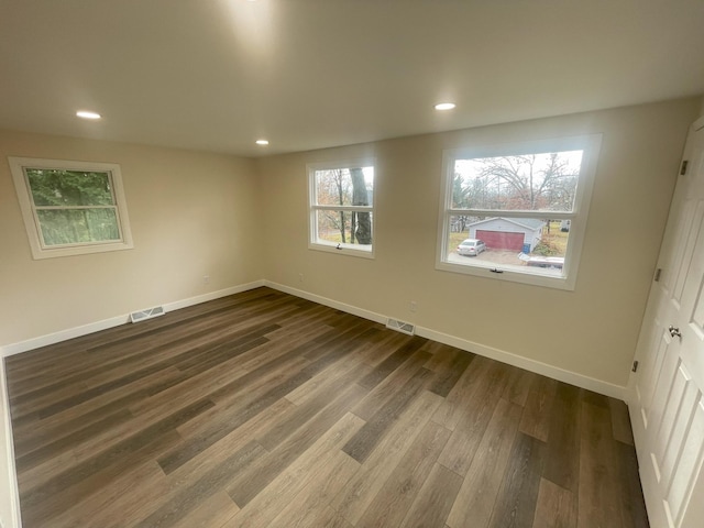 empty room featuring baseboards, visible vents, wood finished floors, and recessed lighting