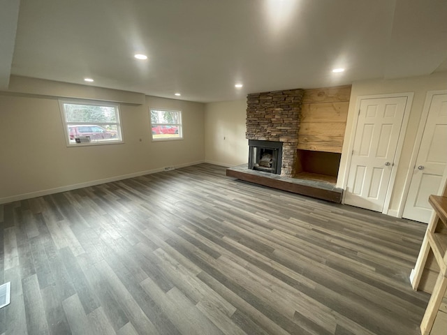 unfurnished living room with recessed lighting, a fireplace, baseboards, and wood finished floors