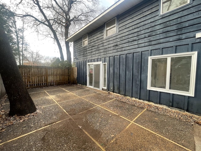 view of side of property with board and batten siding and fence