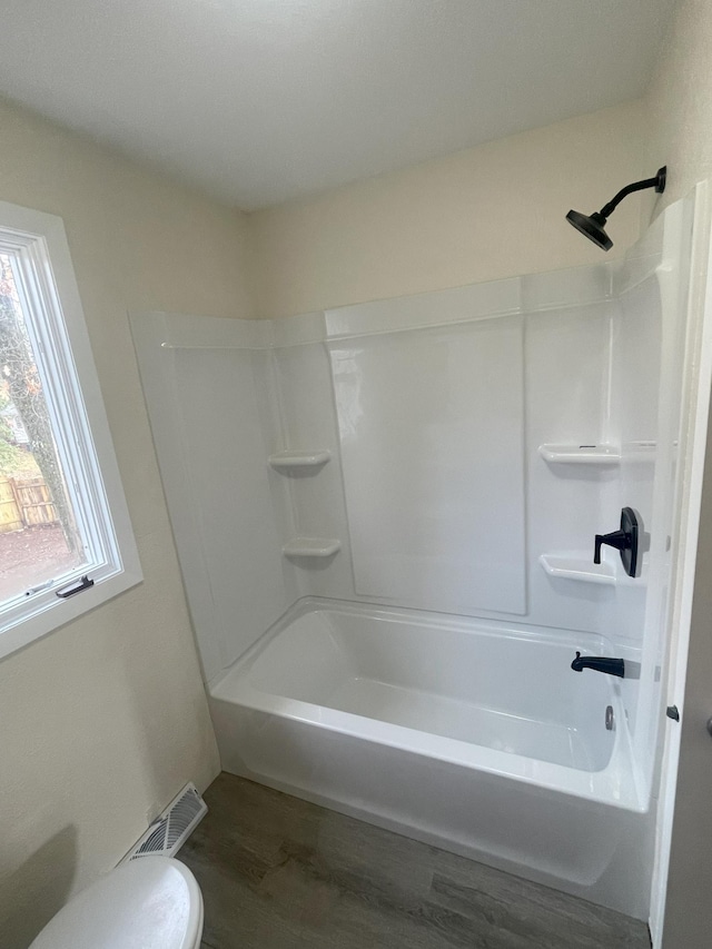 full bathroom with visible vents, toilet, shower / bathtub combination, and wood finished floors