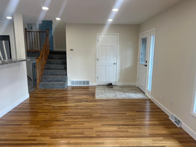 interior space featuring recessed lighting, wood finished floors, visible vents, baseboards, and stairway