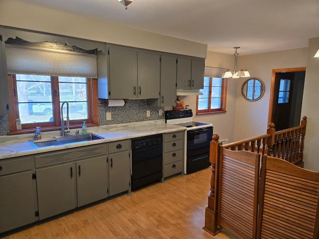 kitchen with black appliances, gray cabinetry, backsplash, light wood-type flooring, and pendant lighting