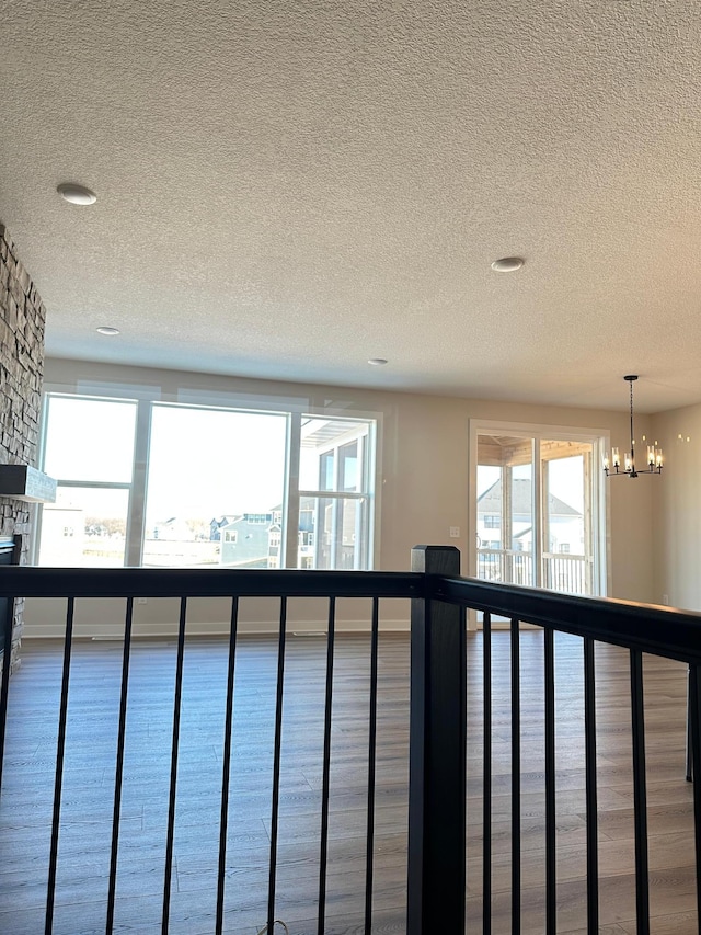 interior space featuring a notable chandelier, a stone fireplace, and a textured ceiling