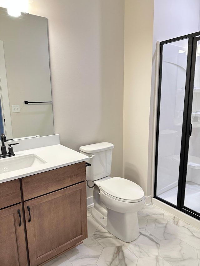 bathroom with vanity, a shower with door, and toilet