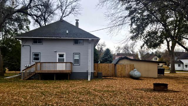 back of house featuring a lawn and a deck