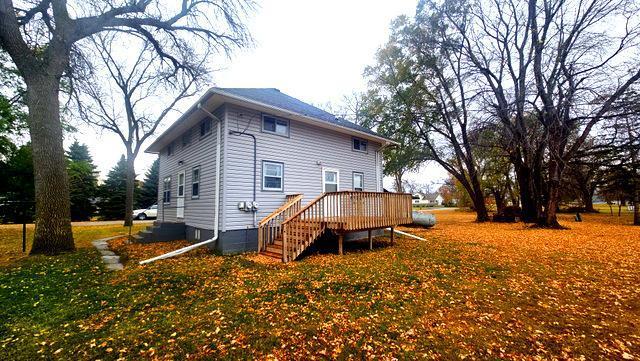 back of house with a deck and a lawn