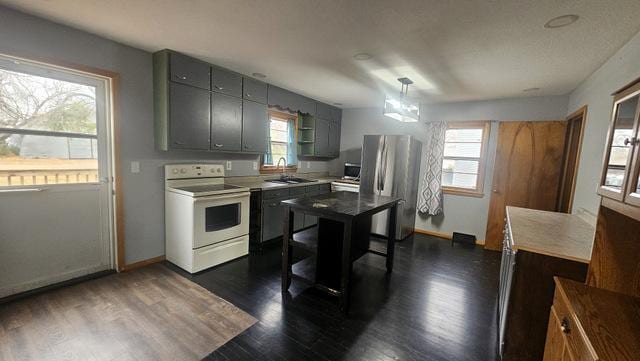 kitchen with stainless steel refrigerator, plenty of natural light, and white range with electric cooktop