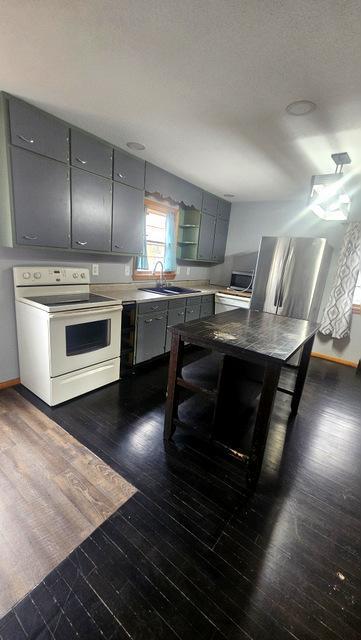 kitchen featuring sink, a textured ceiling, white range with electric cooktop, gray cabinets, and dark hardwood / wood-style flooring