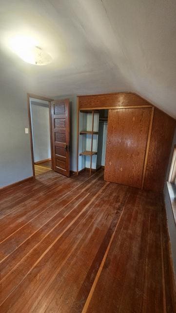 bonus room featuring vaulted ceiling and dark hardwood / wood-style flooring