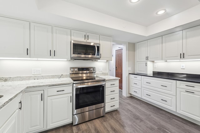 kitchen featuring white cabinets, stainless steel appliances, and dark hardwood / wood-style floors