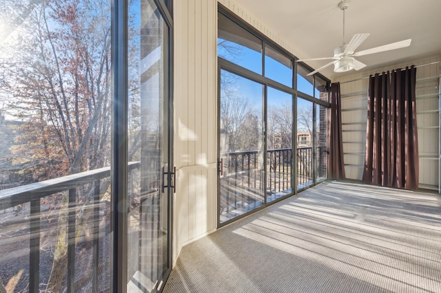 unfurnished sunroom with ceiling fan