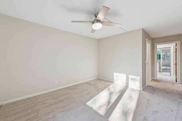 spare room featuring ceiling fan and light colored carpet