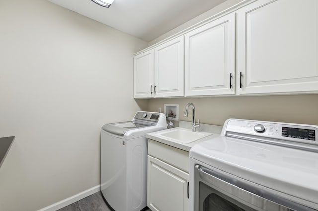 laundry room featuring dark hardwood / wood-style flooring, cabinets, sink, and washing machine and clothes dryer