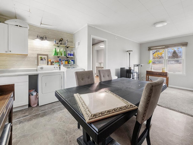 carpeted dining space with separate washer and dryer and crown molding