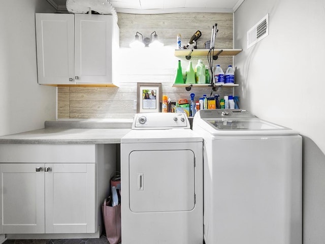 washroom featuring washer and clothes dryer and cabinets