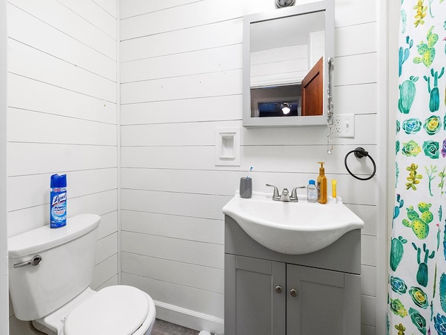 bathroom featuring vanity, curtained shower, toilet, and wooden walls