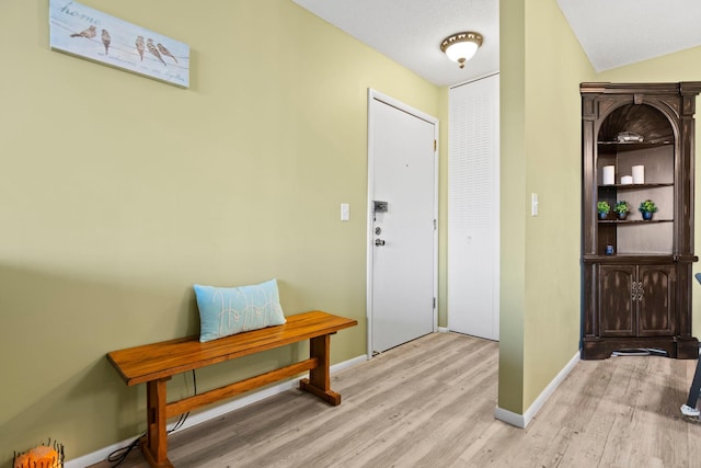 entryway with light hardwood / wood-style floors and vaulted ceiling