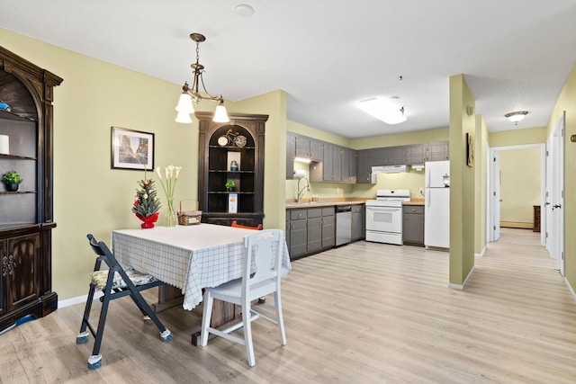 dining area featuring sink, light hardwood / wood-style flooring, and a notable chandelier