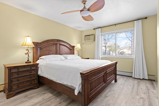 bedroom featuring light hardwood / wood-style floors, ceiling fan, a baseboard radiator, and a wall mounted AC