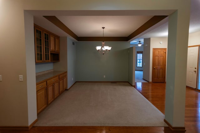 kitchen with decorative light fixtures, light hardwood / wood-style floors, and ceiling fan with notable chandelier