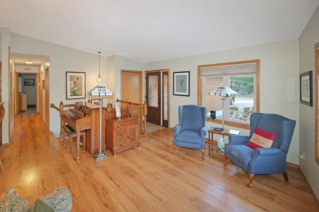 sitting room with light hardwood / wood-style flooring and lofted ceiling