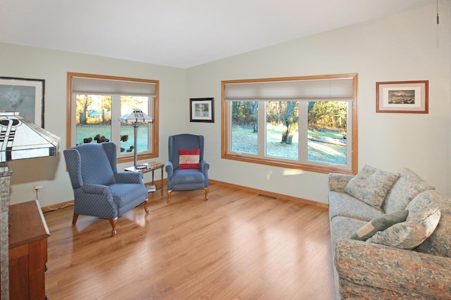 sitting room with hardwood / wood-style floors and lofted ceiling