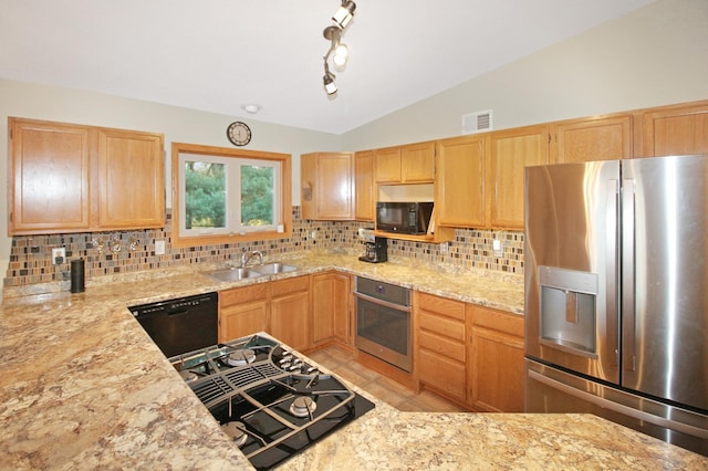 kitchen with light stone countertops, sink, backsplash, vaulted ceiling, and black appliances