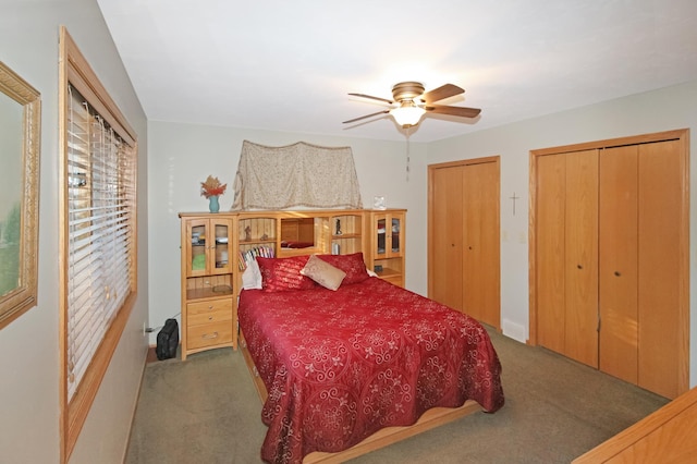 bedroom with carpet, ceiling fan, and two closets