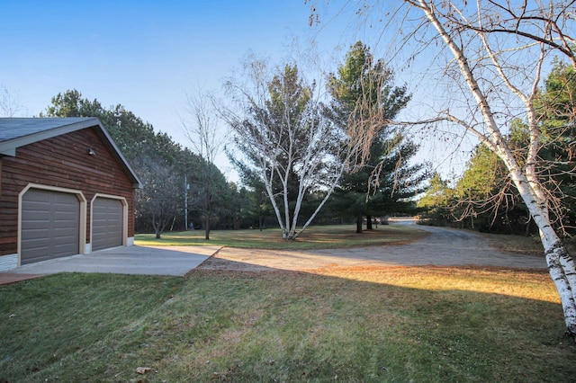 view of yard featuring a garage and an outdoor structure